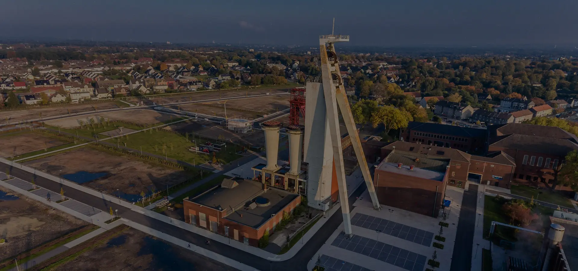 Luftaufnahme eines Förderturms mit umliegenden Gebäuden und einer weitläufigen Landschaft in Herten.